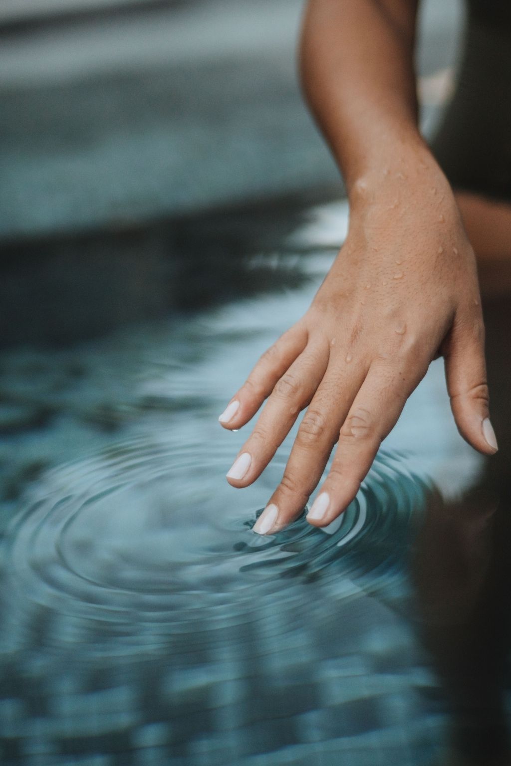 Main de femme dans un bassin d'eau thermale