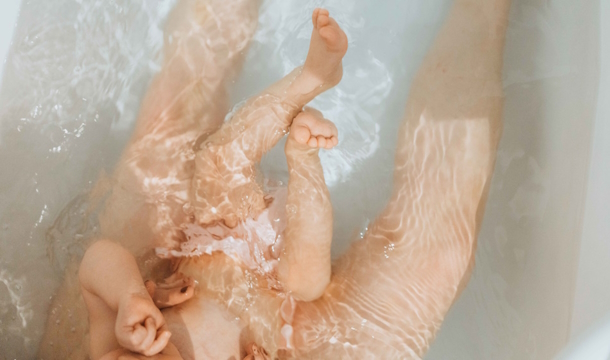 Jambes de bébé et sa maman dans un bain d'eau thermale