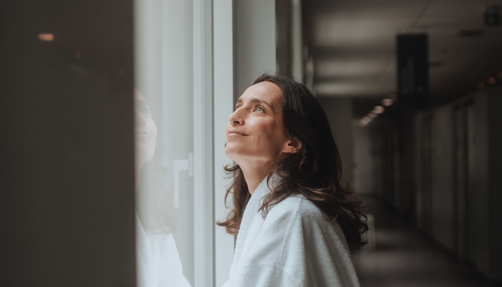 Femme en cure qui regarde par la fenêtre